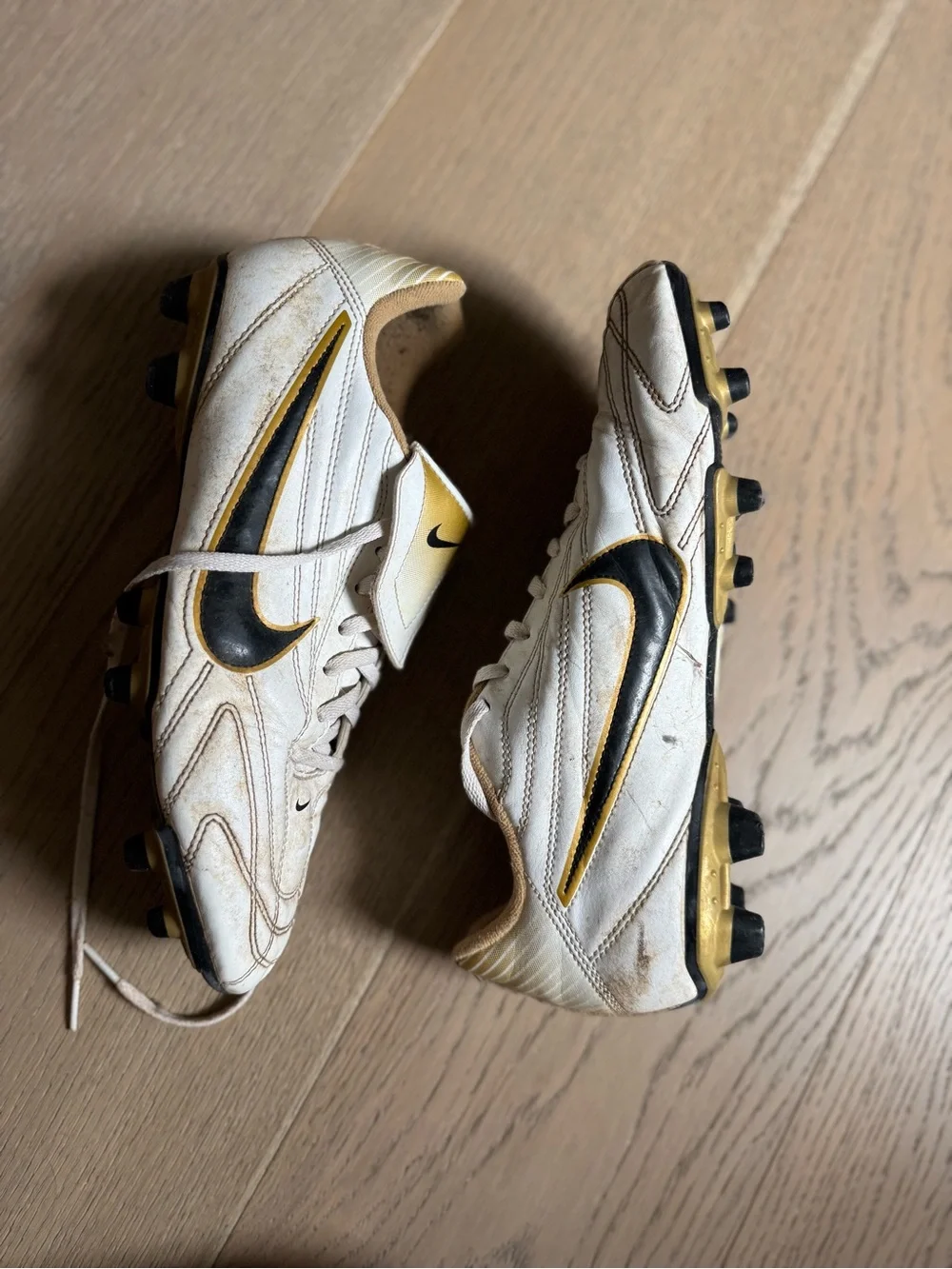 Nike Men’s White Soccer Shoes with Black Swoosh and Gold Highlights